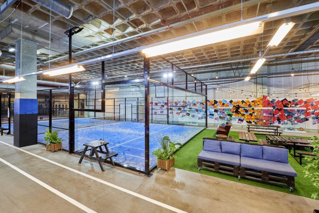 Indoor padelbaan aan de Johan Huizingalaan met zitgelegenheid en kleurrijke muurschildering.